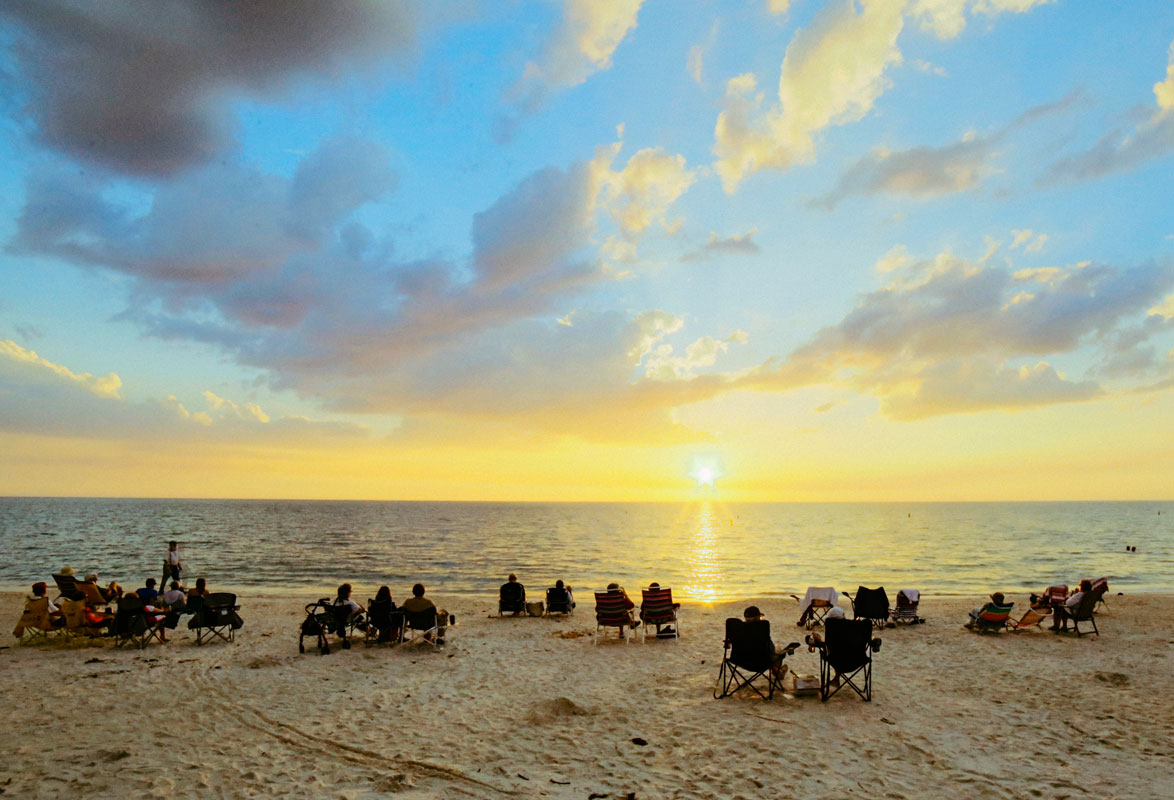 Beach chairs crowd sunset